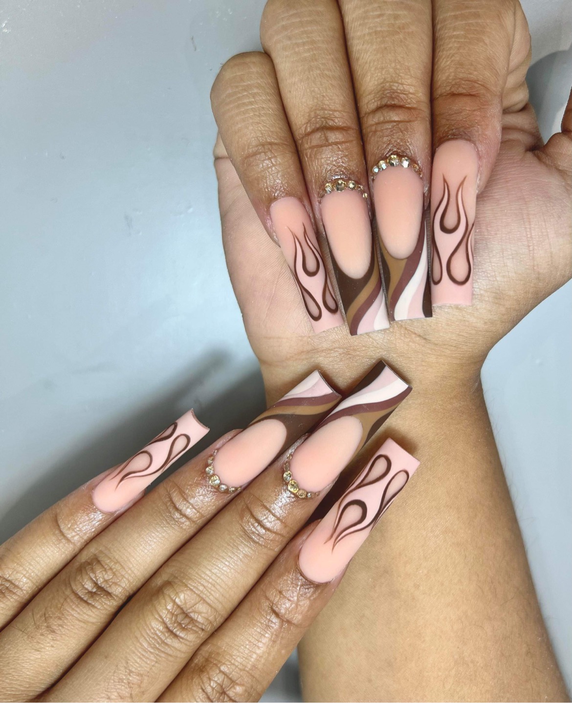 Matte nude nails with brown flame design